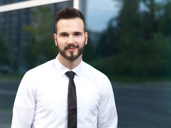 Amistoso y sonriente hombre de negocios guapo mirando con confianza — Foto de Stock