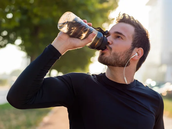 Knappe man drinkwater op een zonnige dag — Stockfoto