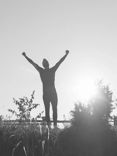 Successful man raising arms after cross track running on summer — Stock Photo, Image