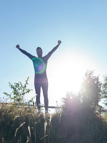 Successful man raising arms after cross track running on summer — Stock Photo, Image