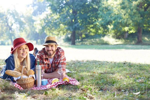 Прекрасная молодая пара устраивает пикник в сельской местности. Счастливая семья — стоковое фото