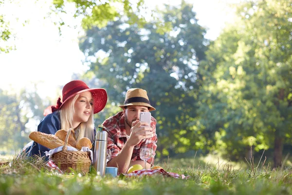 Композит пари, що приймає селфі на смартфон на романтичному пікніку — стокове фото