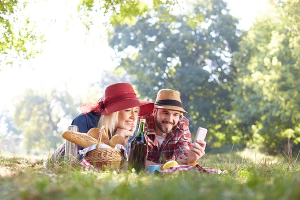 Kompozitní selfie brát pár na smartphone na romantický piknik — Stock fotografie
