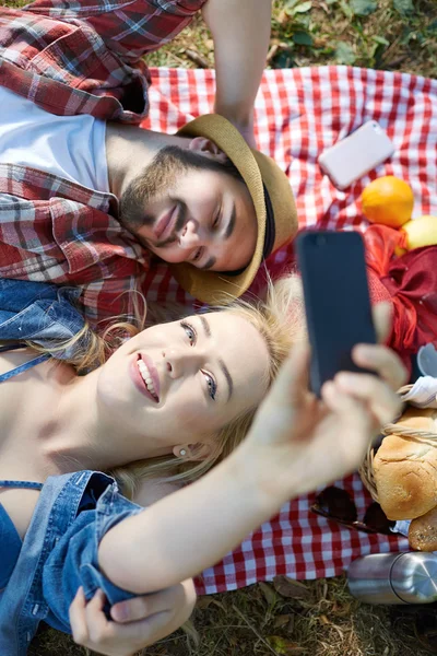 Composiet van paar nemen selfie op smartphone op romantische picn — Stockfoto