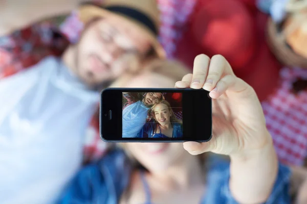 Composiet van paar nemen selfie op smartphone op romantische picknick — Stockfoto