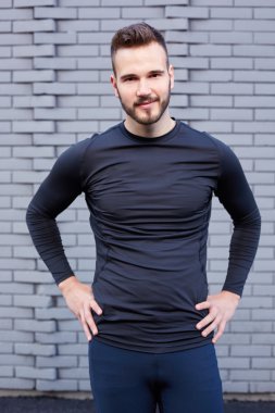T-shirt ayakta çimento duvar amaç karşı erkek koşucu gülümseyen