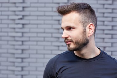 T-shirt ayakta çimento duvar amaç karşı erkek koşucu gülümseyen