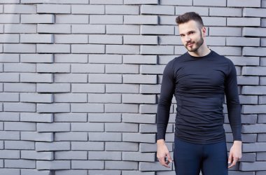 T-shirt ayakta çimento duvar amaç karşı erkek koşucu gülümseyen