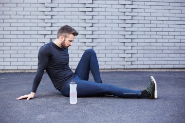 Beton duvara germe sakallı spor adam