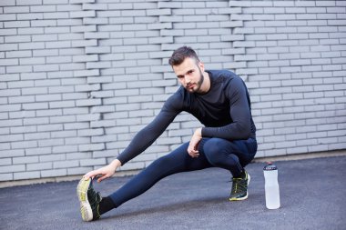 Beton duvara germe sakallı spor adam