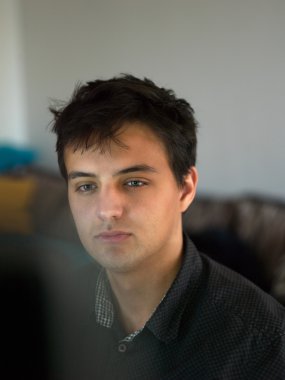 Ofiste dizüstü bilgisayarla çalışan yakışıklı iş adamı.