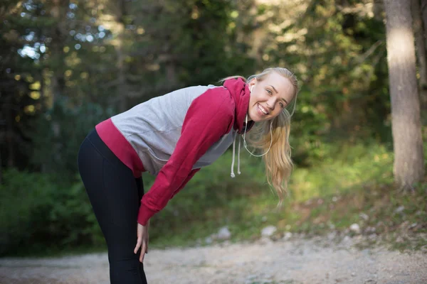 Joven corredora en sudadera con capucha está corriendo en la naturaleza —  Fotos de Stock