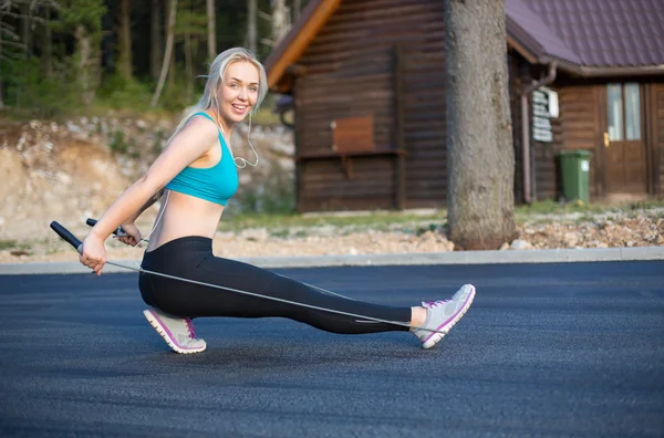 Aktive junge Frau springt mit Springseil im Freien — Stockfoto