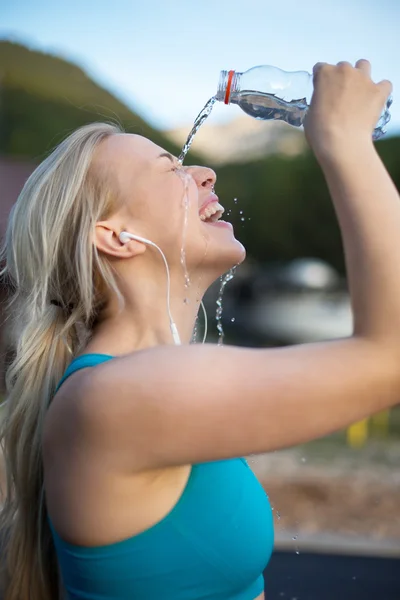 Vrouw fitness runner drinken en spatten in haar gezicht. F — Stockfoto