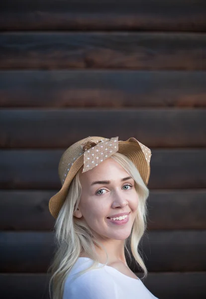 Vrouw met hoed op houten muur achtergrond — Stockfoto