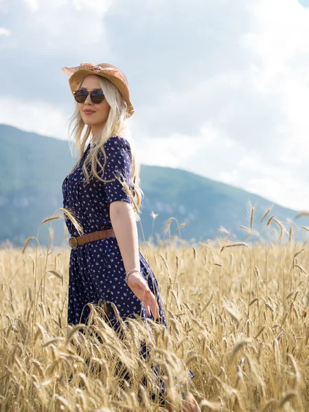 Junge Frau im Sommerkleid auf dem Feld — Stockfoto