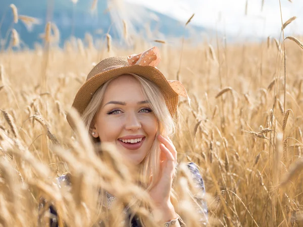 Jeune femme appréciant la nature et la lumière du soleil dans un champ de paille — Photo