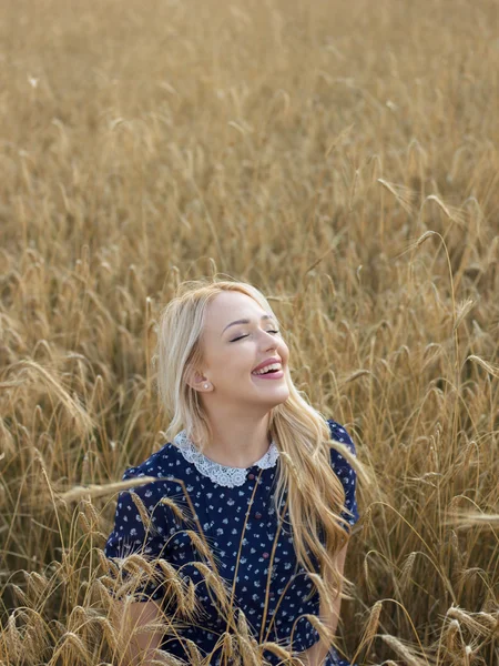 Jeune femme appréciant la nature et la lumière du soleil dans un champ de paille — Photo