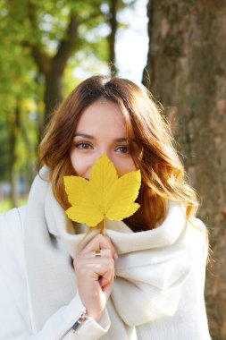 Sonbahar ile neşeli genç kadın portresi f önünde yapraklar
