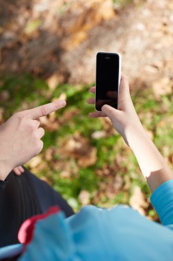 Genç kadın koşu sonra rahatlatıcı. O akıllı telefonunu kullanarak ve