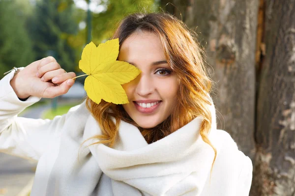 Портрет веселой молодой женщины с осенними листьями перед... — стоковое фото
