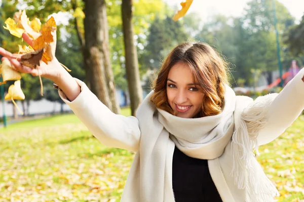 Портрет веселой молодой женщины с осенними листьями перед... — стоковое фото