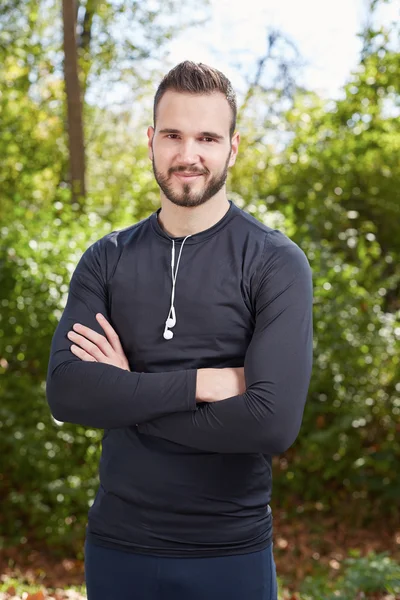 Hombre deportivo guapo corredor cansado descansando después de trotar por la noche, en forma — Foto de Stock