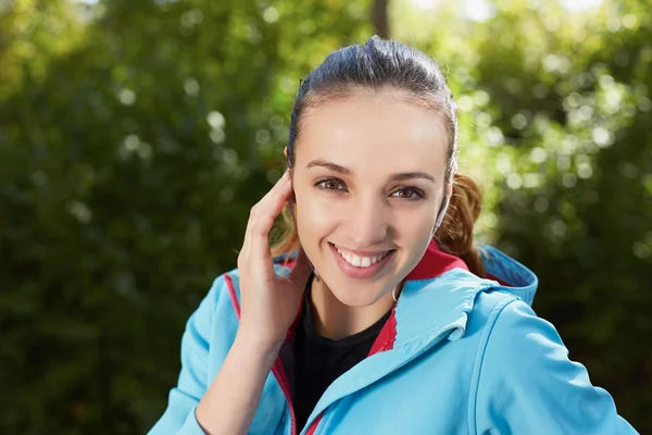 Retrato de un corredor escuchando música en auriculares mientras está corriendo — Foto de Stock