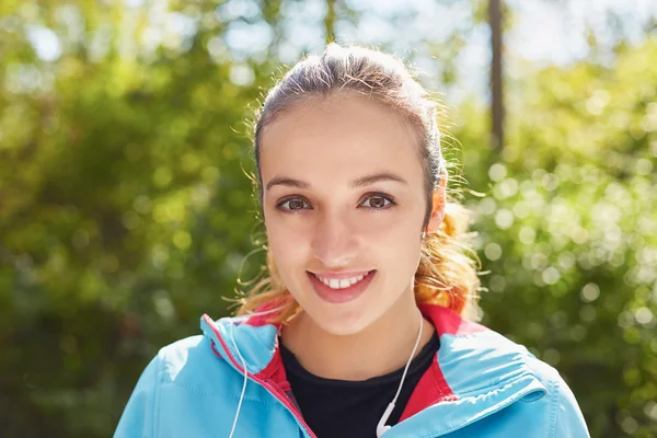 Portrait of a runner listening to music on headphones while runn — Stock Photo, Image