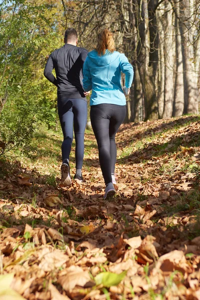Mladý běžící pár běhání v podzimní přírodě — Stock fotografie