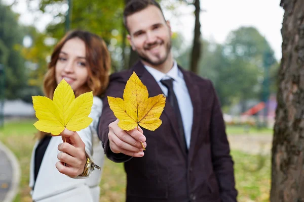 Joyeux jeune couple amoureux en plein air, couple tenant congé d'automne — Photo