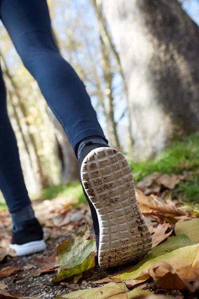 Fechar-se de pés de um corredor que corre no outono deixa o treinamento f — Fotografia de Stock