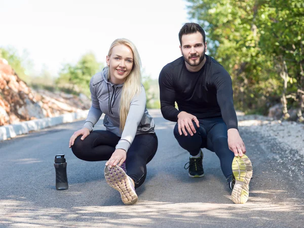 Retrato de alegre pareja caucásica corriendo al aire libre. Corredores — Foto de Stock