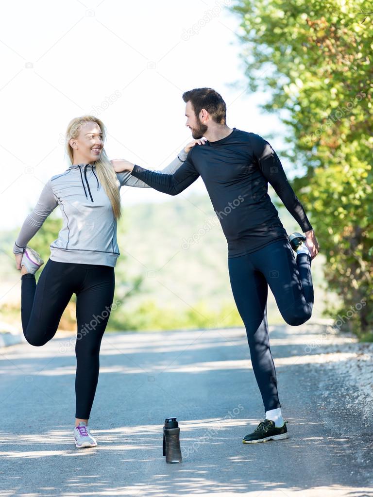 Portrait of cheerful Caucasian couple running outdoors. Runners