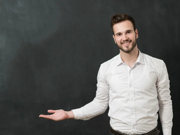 Young man against chalkboard — 图库照片