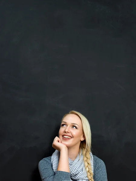 Kvinna med krita på en tom svart tavla — Stockfoto