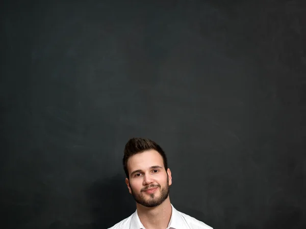 Porträt eines ernsthaften jungen Mannes, der an der Tafel steht — Stockfoto