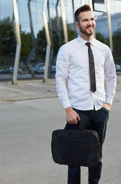 Amable y sonriente hombre de negocios guapo en frente de la construcción — Foto de Stock