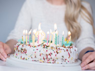 sarışın kız Doğum günü pastası ve üfleme ile plaka tutarak yapma arzusu mumlar