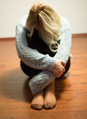 Yalnız boş bir odada oturan üzgün kadın