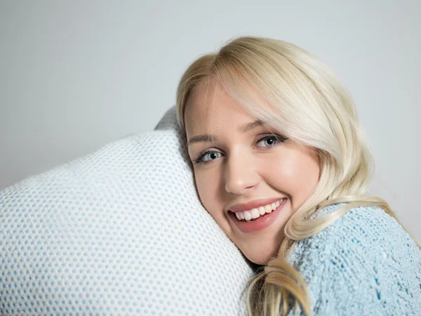 Close up van een charmante vrouw met kussen zittend op haar bed blik — Stockfoto