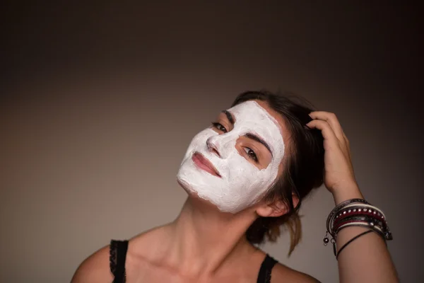 Young emotional woman with facial mask