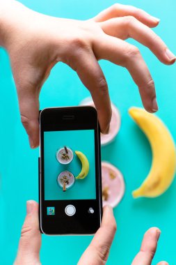 Eller fotoğraf blueberry smoothie smartphone ile alarak.