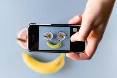 Eller fotoğraf blueberry smoothie smartphone ile alarak.