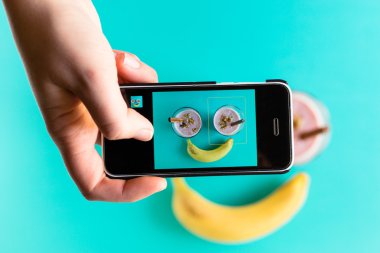 Eller fotoğraf blueberry smoothie smartphone ile alarak.