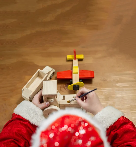 Santa Claus Dokonywanie zabawki. Malarstwo i kolorowanie zabawki drewniane — Zdjęcie stockowe
