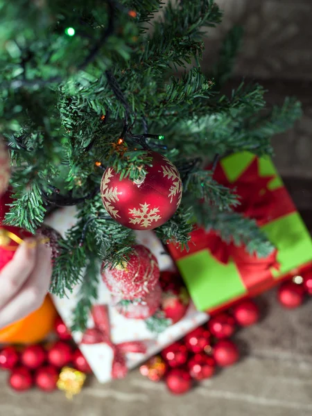 Close-up of man hanging decorative toy ball on Christmas tree br — Stock Photo, Image