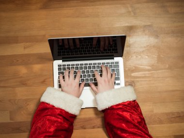 Masa başında çalışma ve bir dizüstü bilgisayar, Noel hediyeleri ve mektuplar yazarak Noel Baba, ellerini görünümü top.