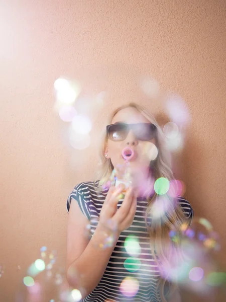 Šťastná mladá žena nosí sluneční brýle s mýdlové bubliny — Stock fotografie