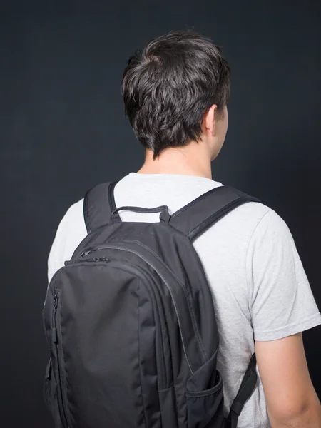 Молодий чоловік стоїть з обладнанням для перевезення рюкзаків ізольовано білий — стокове фото